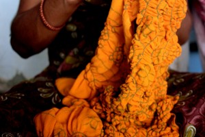 I am currently learning Bandhani and have been working on the same scarf for almost six months, slowly figuring out how to hold a thin thread between my thumb and index finger, and guide it with my pinky to tie knots around tiny bunches of fabric. The first time I tried tying, the tips of my fingers were numb after one hour, and I had only completed four dots.  In the first step of Bandhani production, women tie small knots onto fabric with thin thread. After the knots are tied, the fabric is dipped in dye – the knotted threads protect the fabric underneath from retaining dye. When the dye has dried, the knots are ripped out, exposing small rings of undyed fabric. The above photo shows a scarf tied into knots before it is dyed.  Bandhani dyers use a variety of dying techniques. My bandhani instructor, Jabbar, is a pioneer of natural dyes and travels the world to lead workshops about natural dyes.
