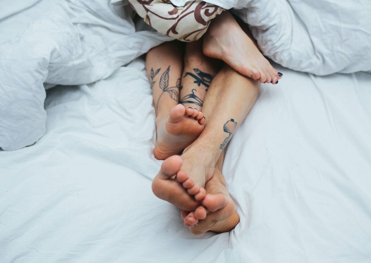 Мужские и женские ноги в кровати