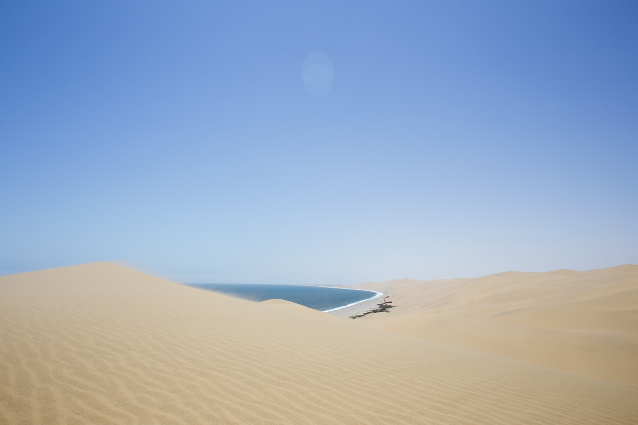 Photo: Sandwich Bay is one of the most fascinating corners of the huge Namib desert. Hundred-meter high dunes of the finest golden sand are halted in their advance by the crashing waves of the South Atlantic. It’s not just the landscape that makes this place unique, it’s also the getting there. Easily arranged at Walvis Bay, you’ll have to hop on a 4x4 dune vehicle for one hell of a ride. Baptized by our driver as, “The Namibian rollercoaster!” 