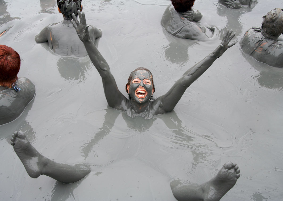 Nude girl in pool of mud