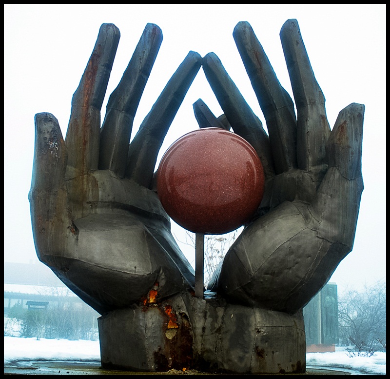 The world is in the iron hands. This Workers' Movement Memorial shows the two hands protecting the granite ball representing the perfect ideology which the workers' movement had perfected.