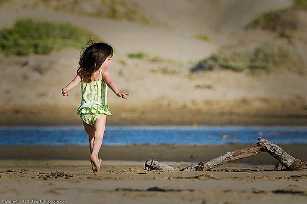 Small child runs on Morro Strand