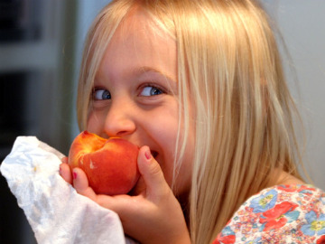 Kid eating peach