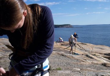 Hooking up a climbing harness in Bar Harbor, Maine