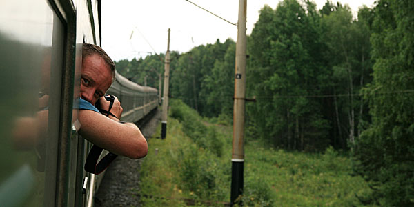 Photographer leaning out of train window