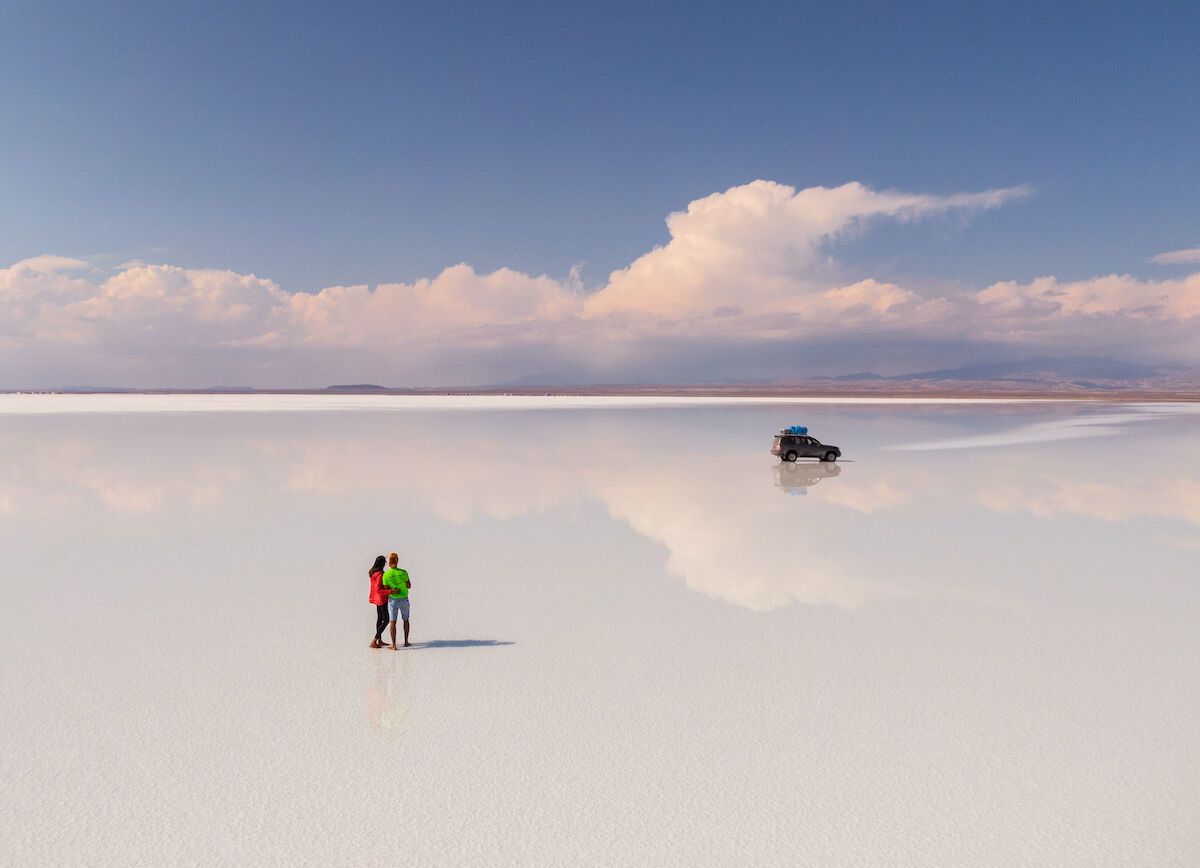 Tourist Couple With Jeep In Salar De Uyuni Bolivia Salt Flats  1200x868 