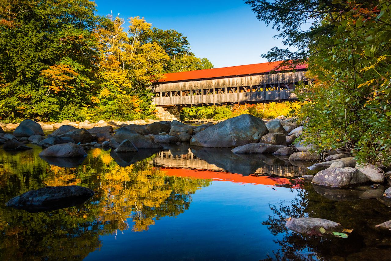 Albany Covered Bridge, along the Kancamagus Highway in White Mountain National Forest, seen on a fall foliage road trip through New England