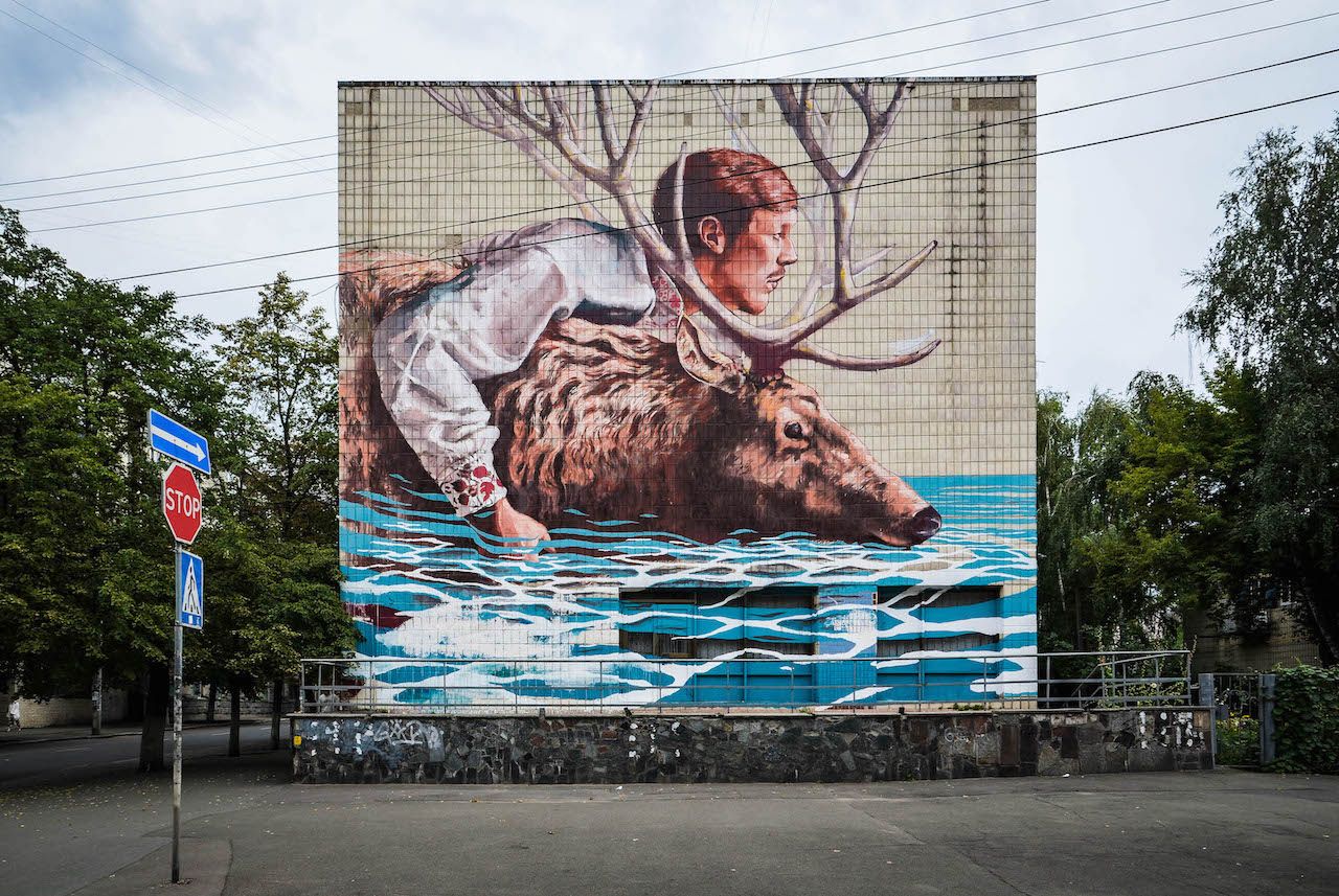 River Crossing by Fintan Magee is a colorful mural painting on a building in Kyiv