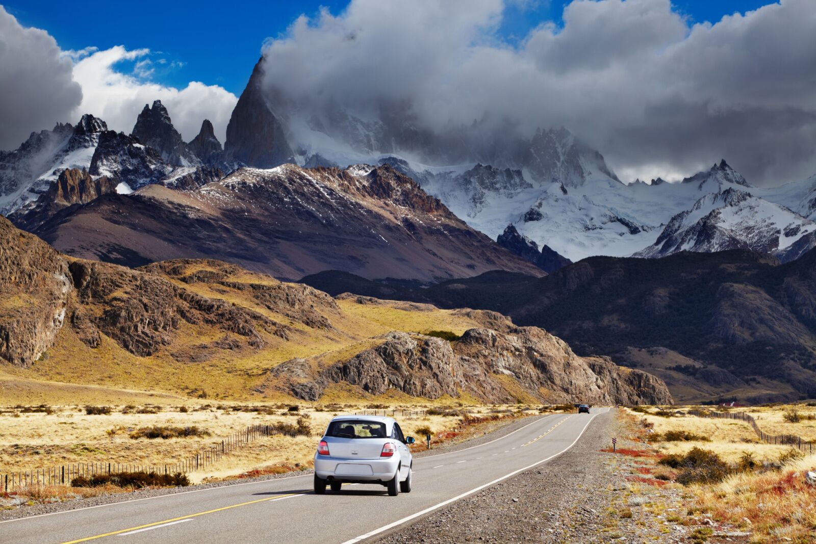 a white car on a road between Chile national parks