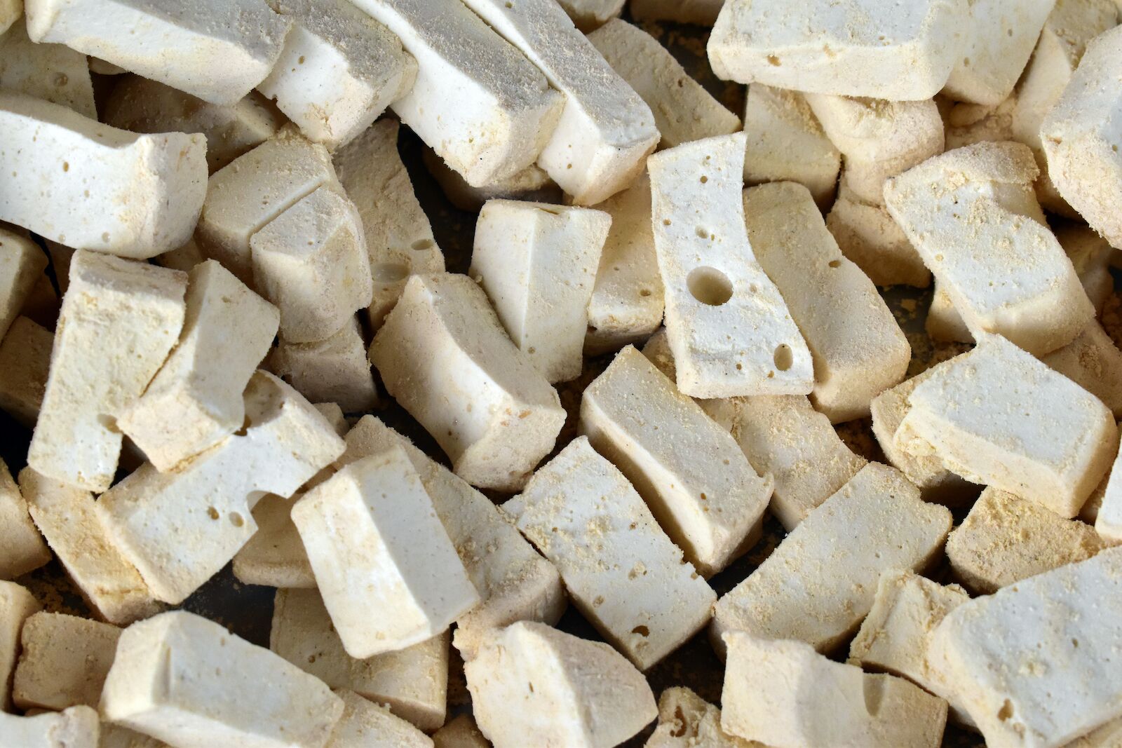 A large amount of rectangluar pieces of white yeot in a pile