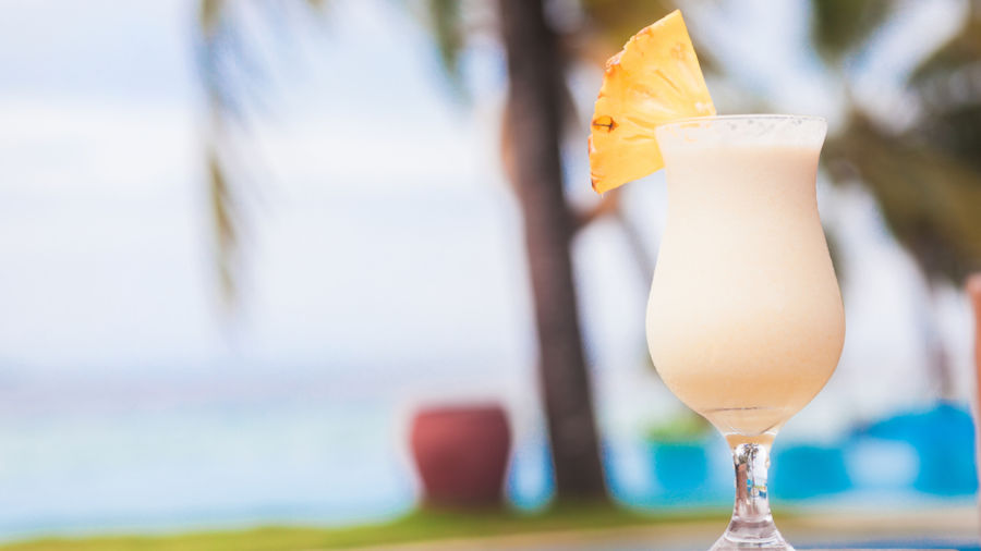 Glass of delicious pina colada cocktail by the sea