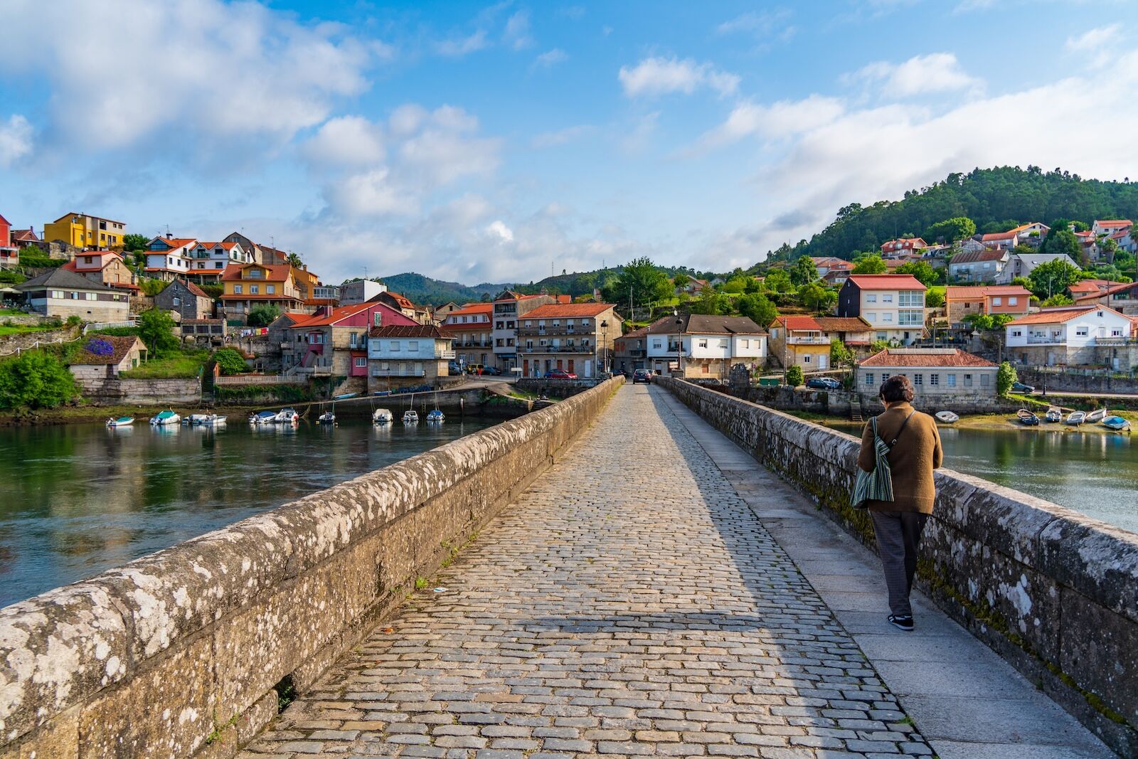 man walking on bridge in pontevedra, spain