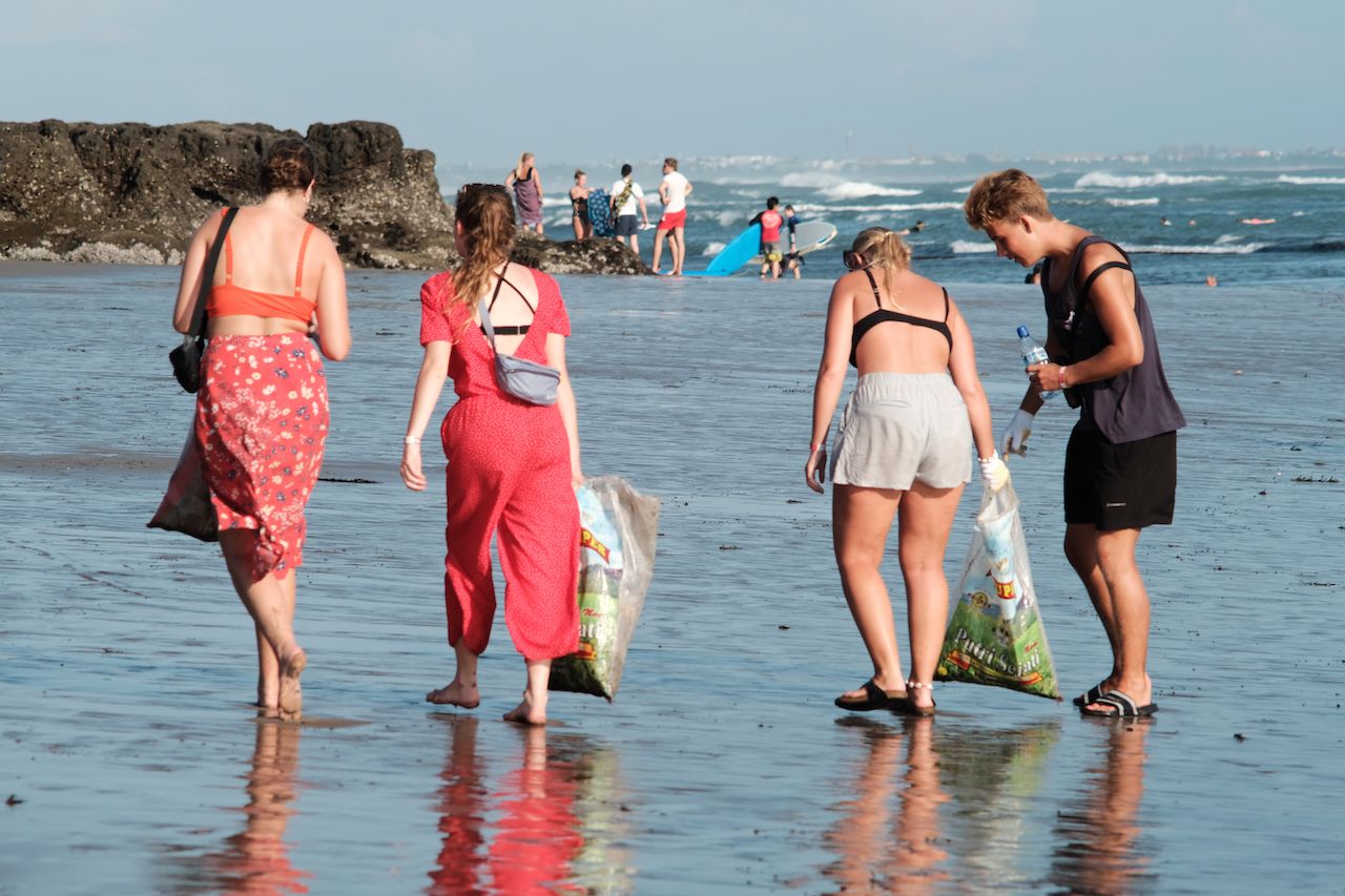People are picking up trash on the beach for 2019 Beach Clean Up event in Canggu