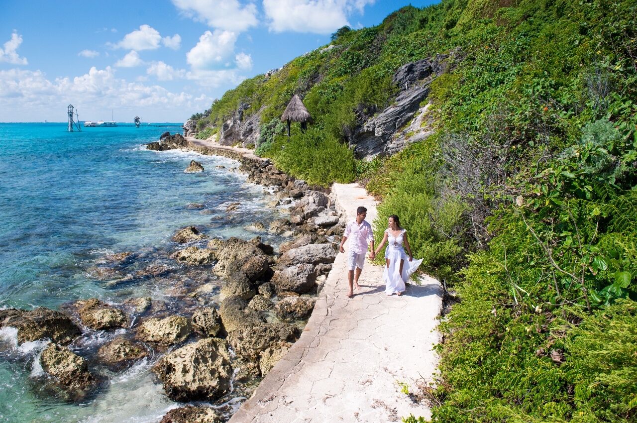Couple walk by the ocean on The Naughty Island, a swingers resort in Belize