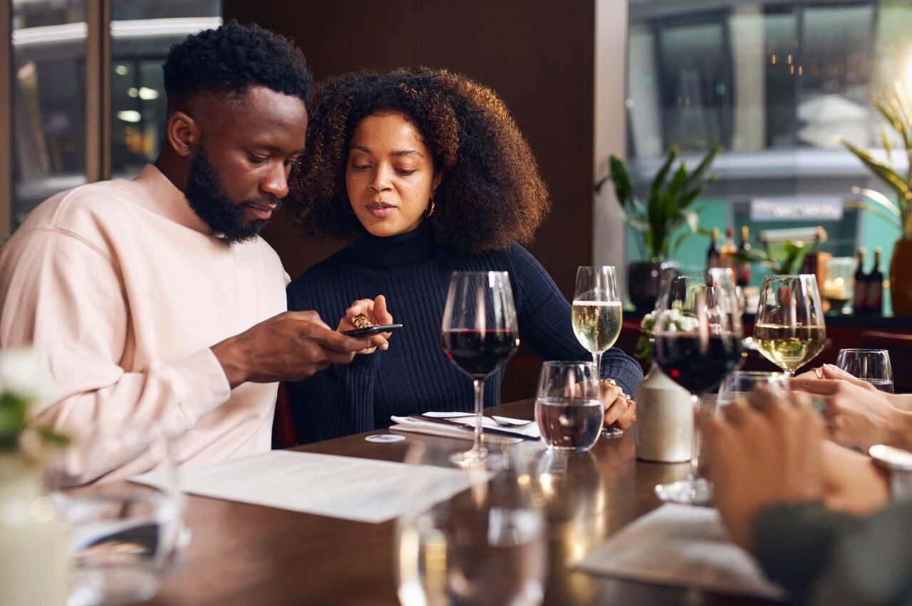 Couple looking at phone in bar on baecation