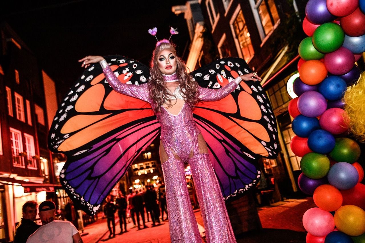 person in butterfly costume in front of gay Amsterdam bar Soho