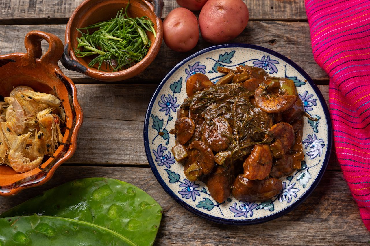 Bowls of prawns, rosemary, and roasted meat with mole sauce are a traditional Christmas dinner in Mexico