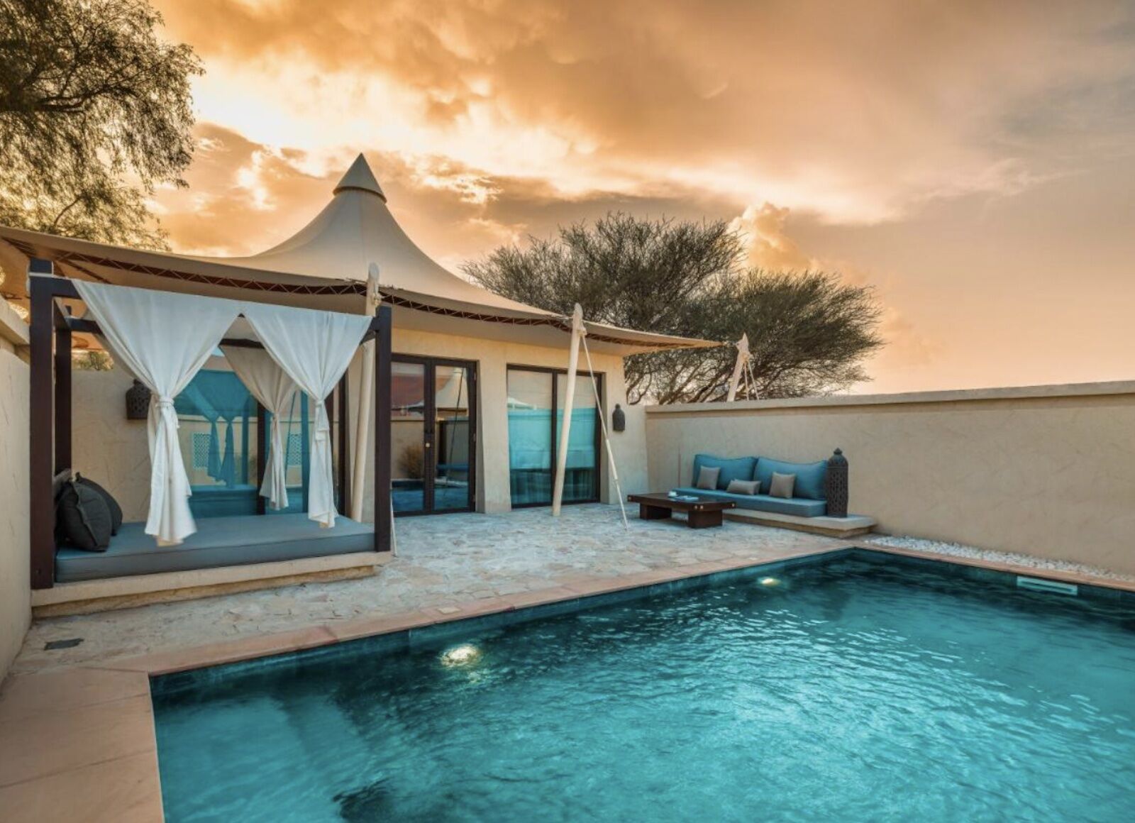A pool and room outside Oman's desert nights camp