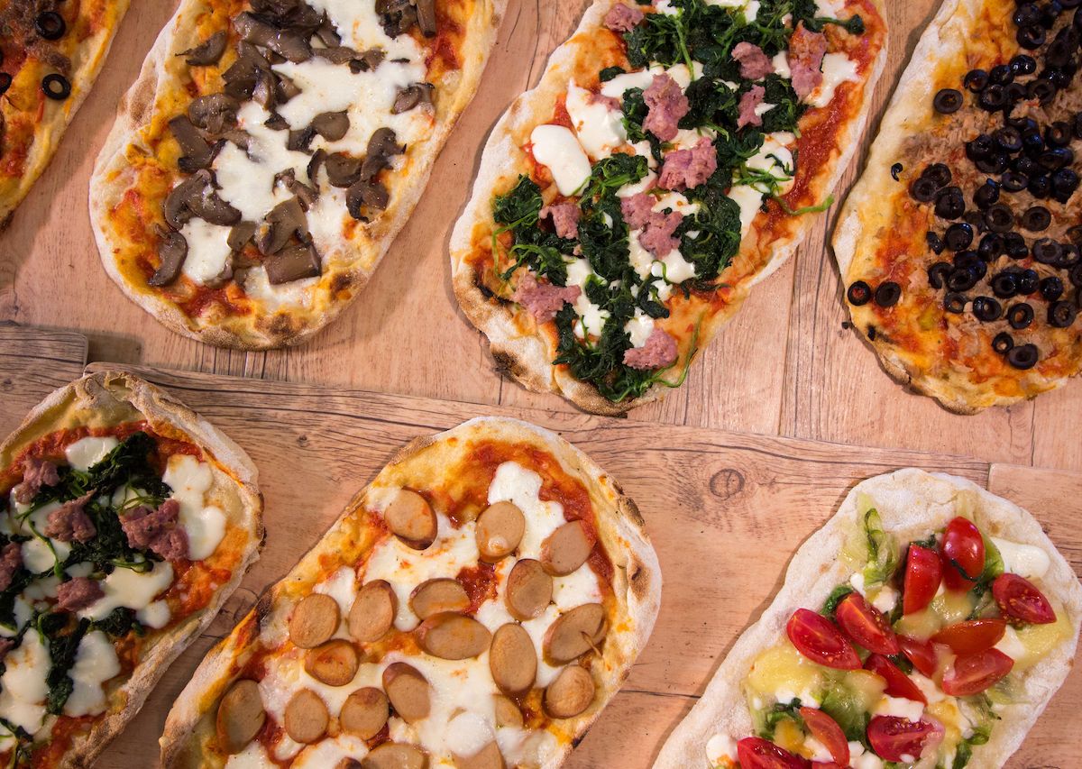 Thin Crust Pizzas Lined Up On A Table 1200x853 