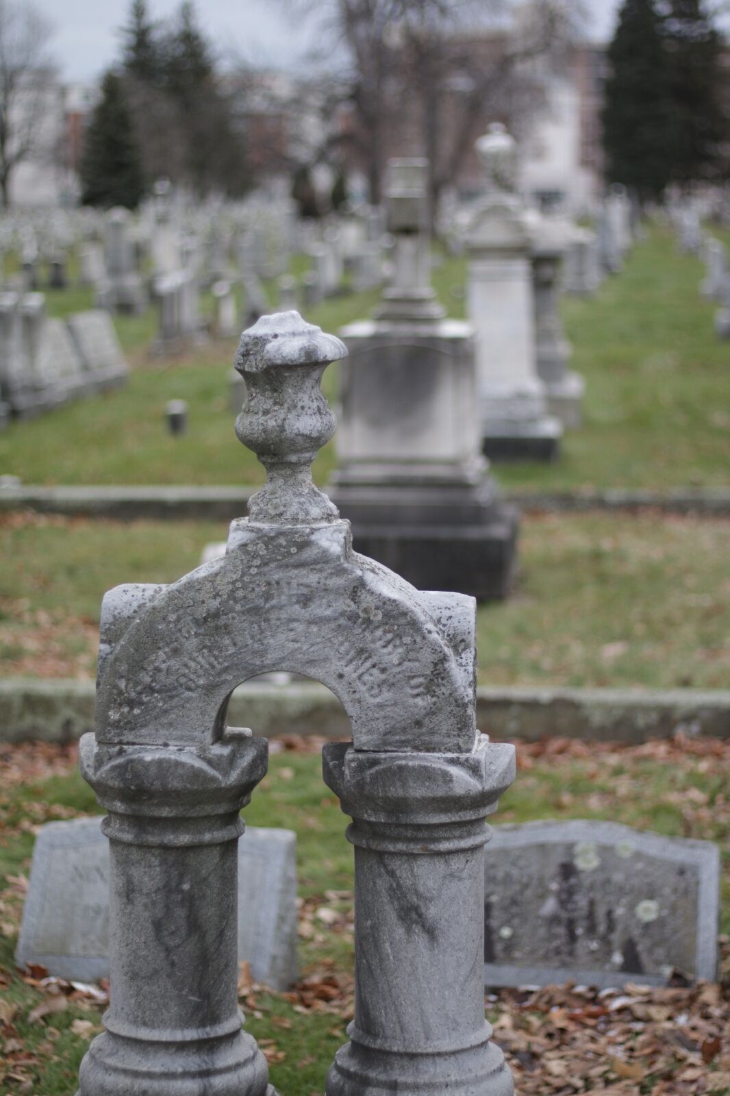 Daytime shallow depth of field picture of grave marker headstone in Mt. Hope cemetery in Rochester, New York