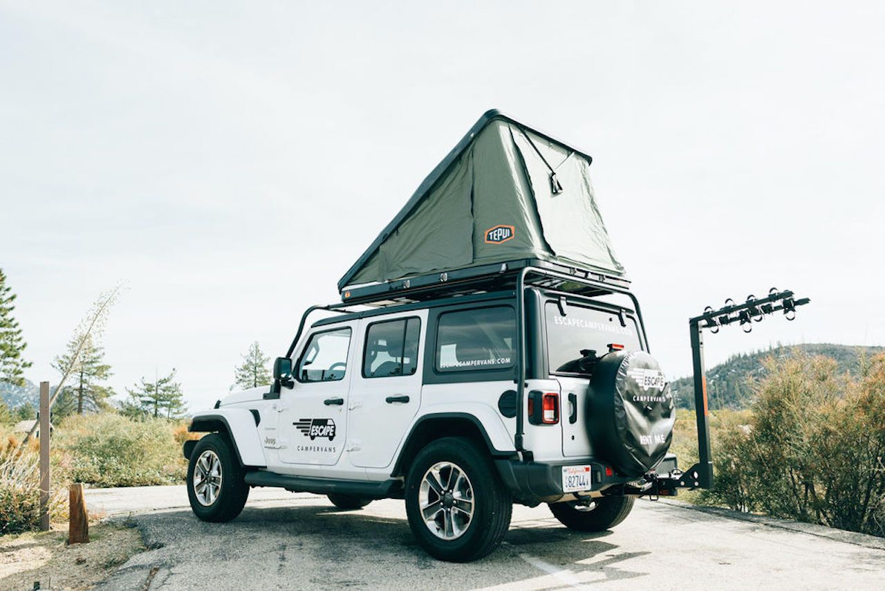 A white 4x4 Rooftop Jeep Camper Rental with winter bedding upgrade