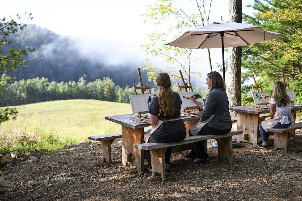 Two women painting outdoors at Blackberry Mountain, one of the top wellness resorts in the US