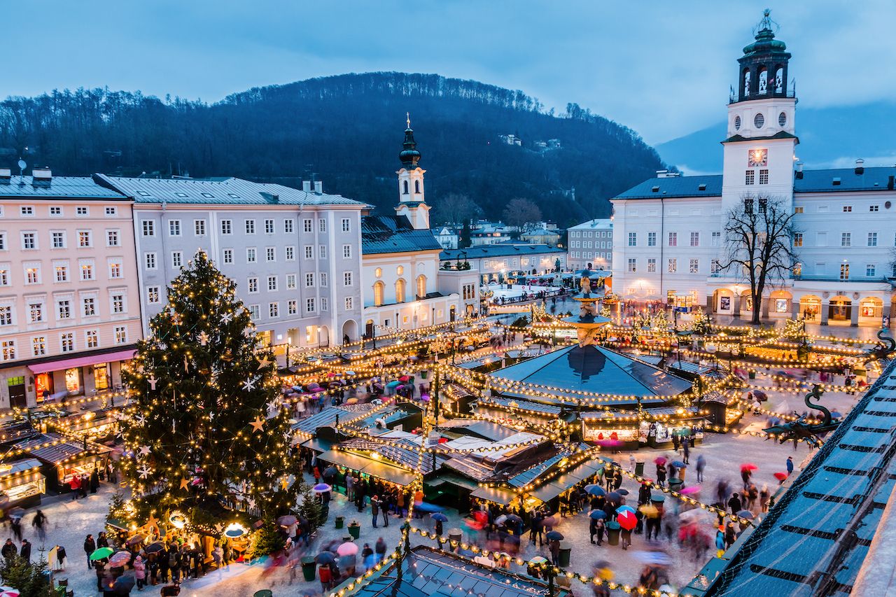 A Christmas market with a large Christmas tree lights up a square in Salzburg, Austria