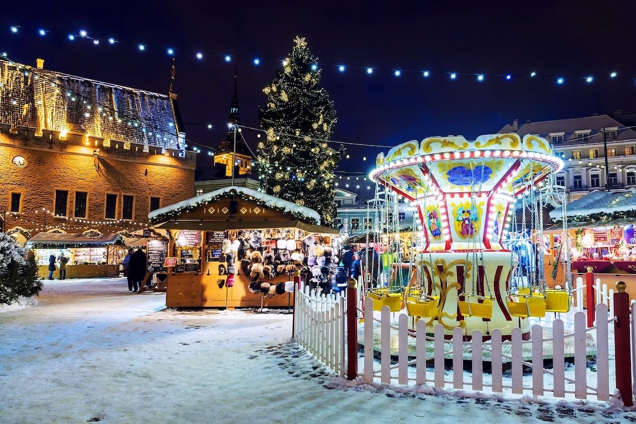 A small carnival ride and food stands in a square in Tallinn, Estonia at Christmas