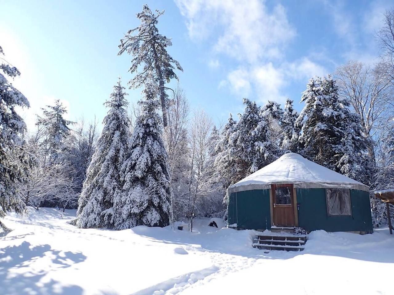 A teal yurt in the snowy woods outside of Montpelier, Vermont