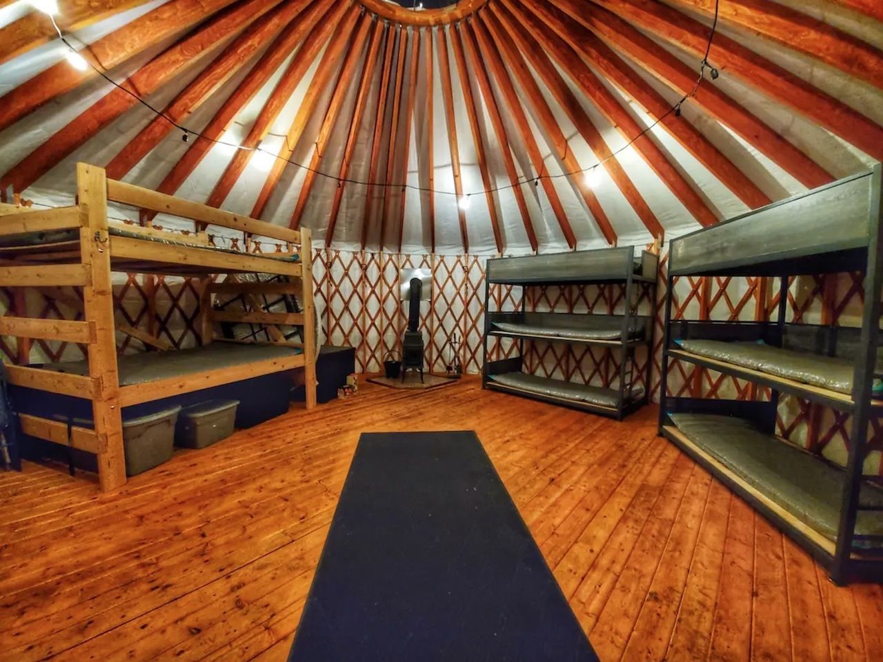 A yurt interior with three bunk beds