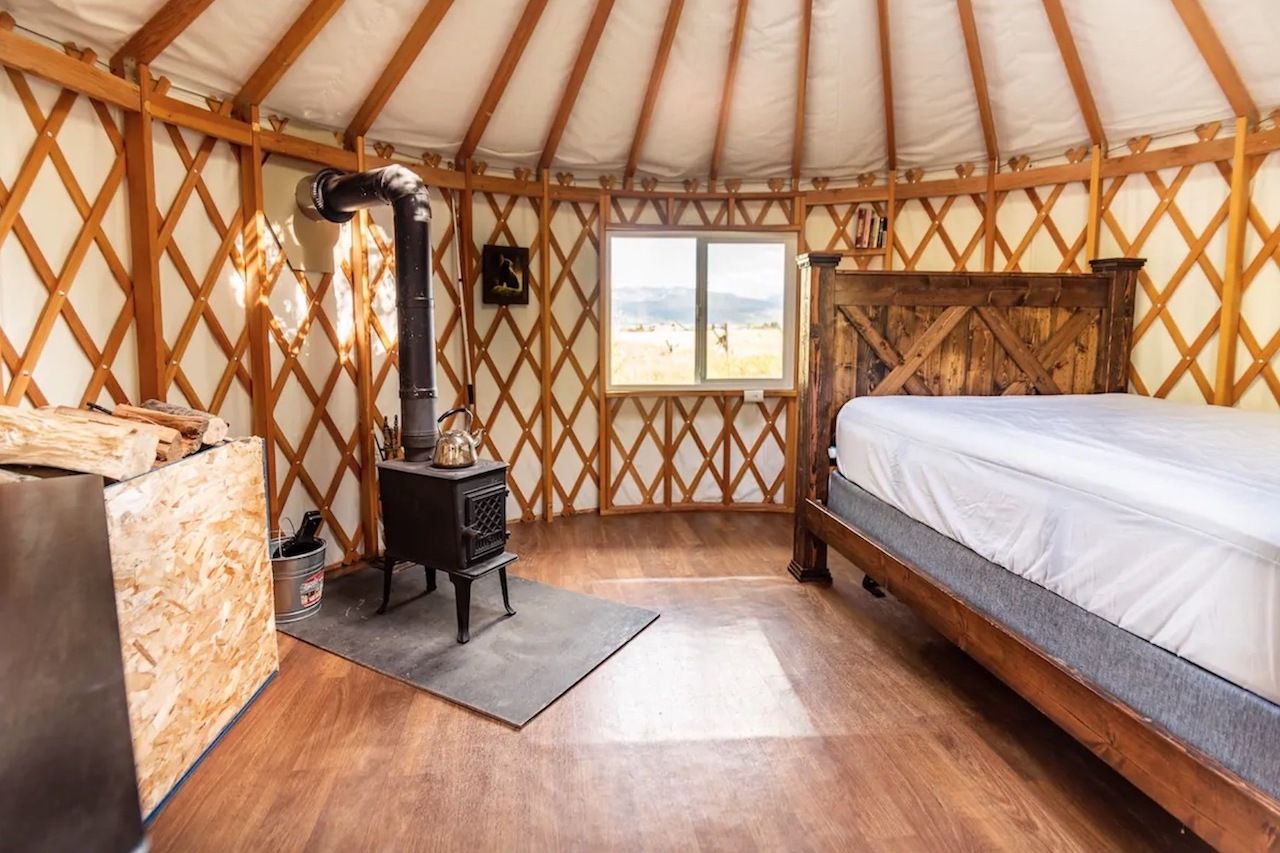The interior of an Airbnb yurt with a wood stove