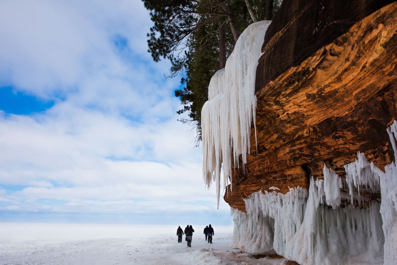 things to do in the midwest in winter - people at wisconsin ice caves with lake on left