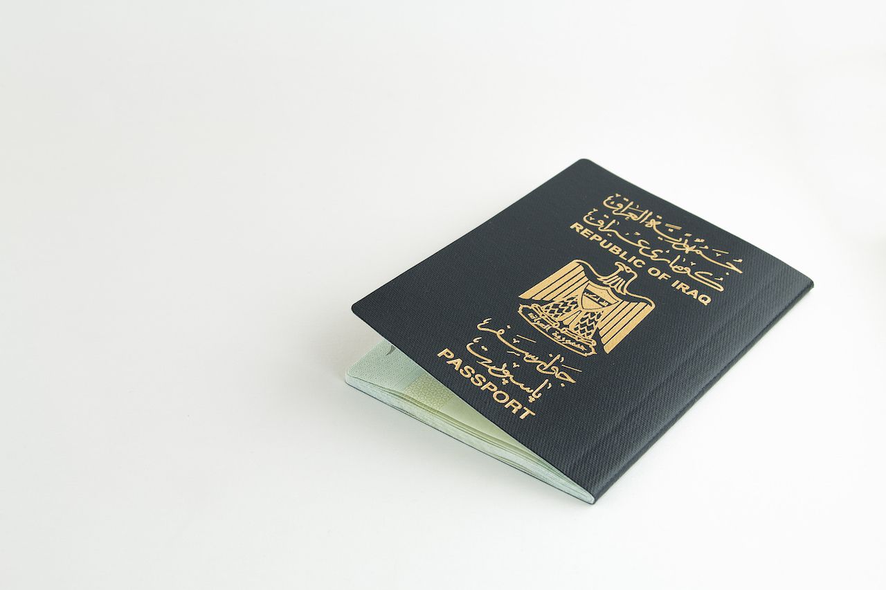 Iraqi passport on white background (opened), weakest passports