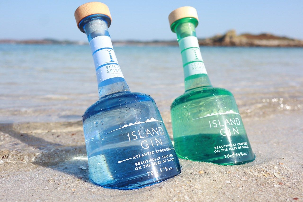 Bottles of Island Gin in the sand at the Isles of Scilly