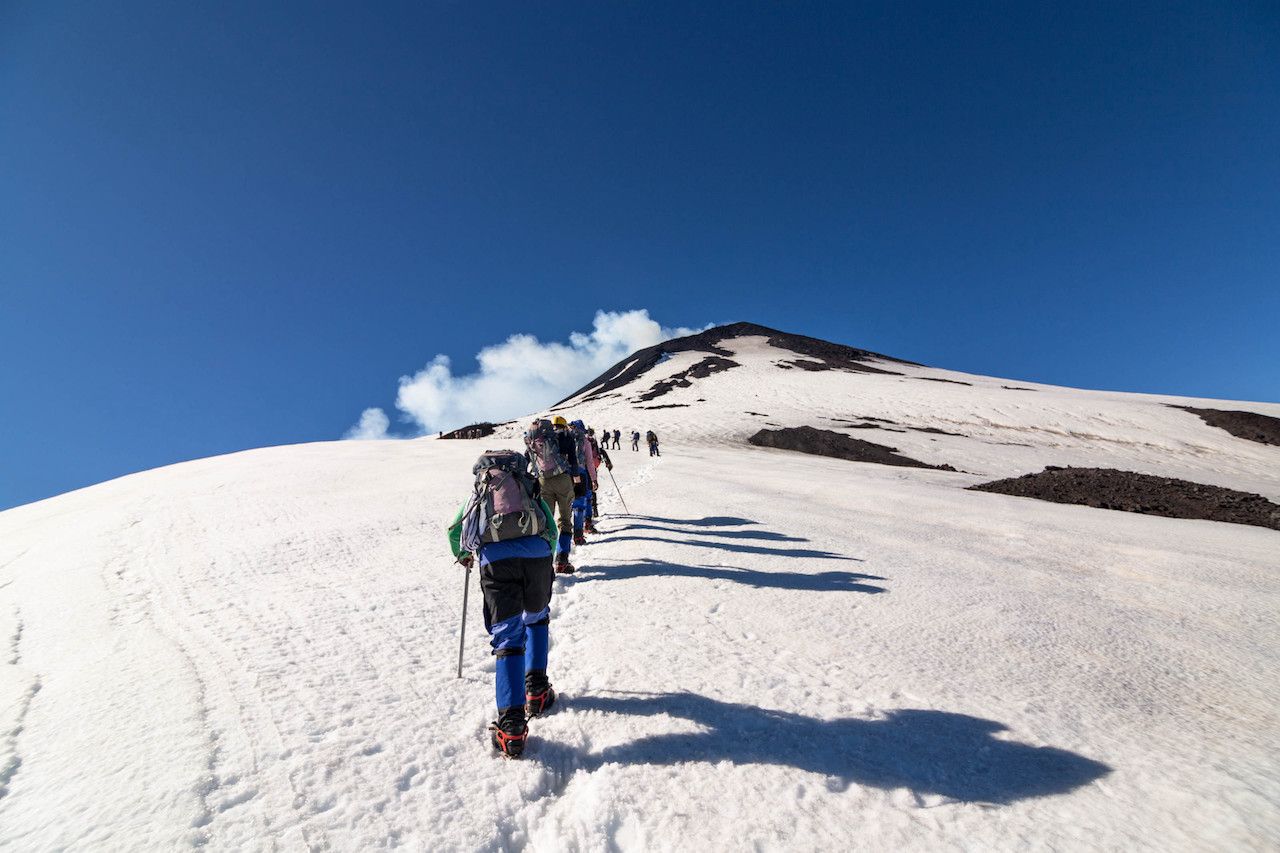 Hiking on snow tethered together on up Volcano Villarrica, Pucon, Chile