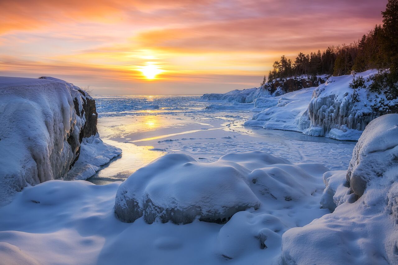 Frozen Lake Superior sunrise at Presque Isle Park, Winter in Marquette, Michigan.