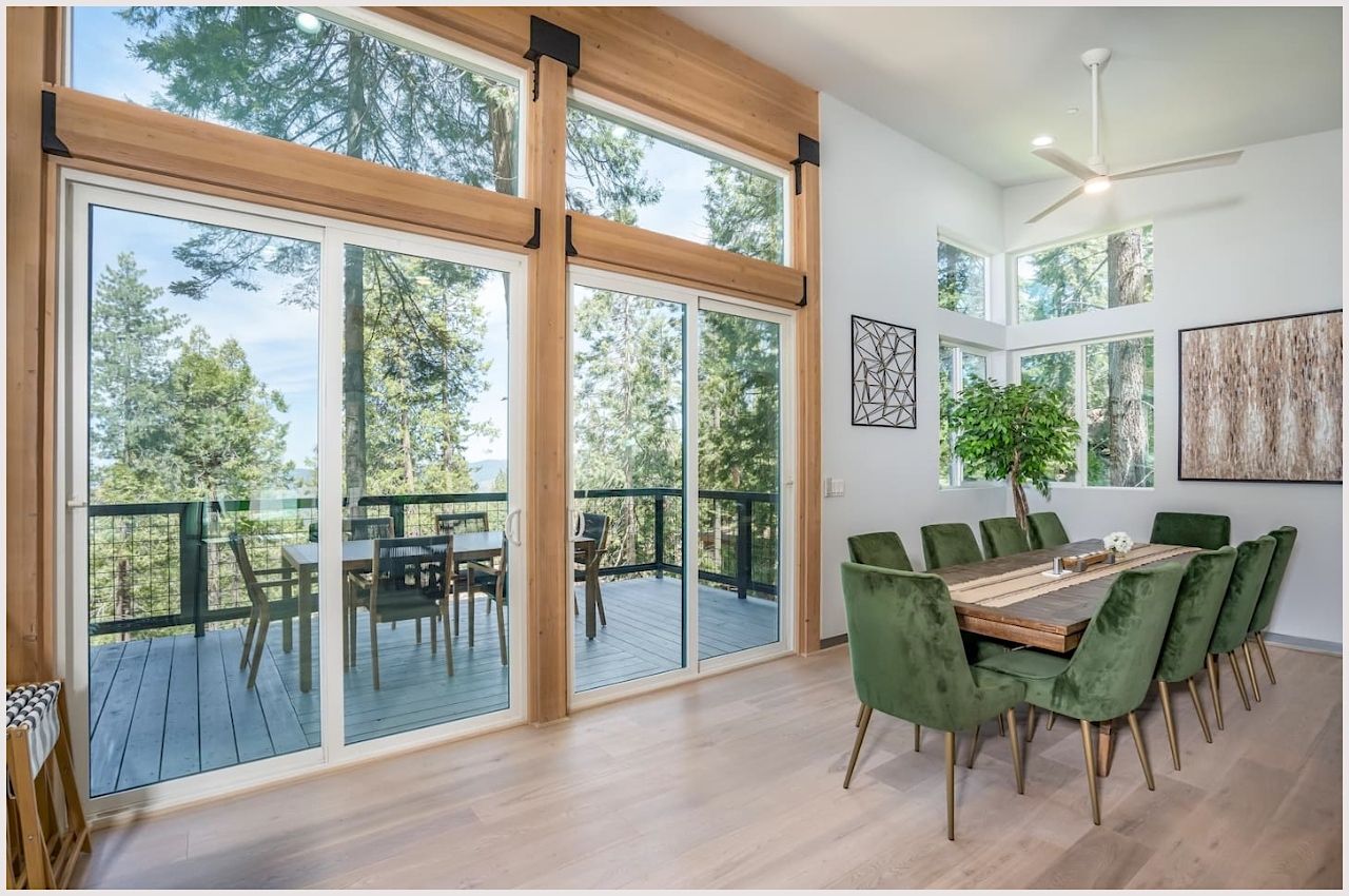 A dining room with floor-to-ceiling windows at a modern Yosemite Airbnb property