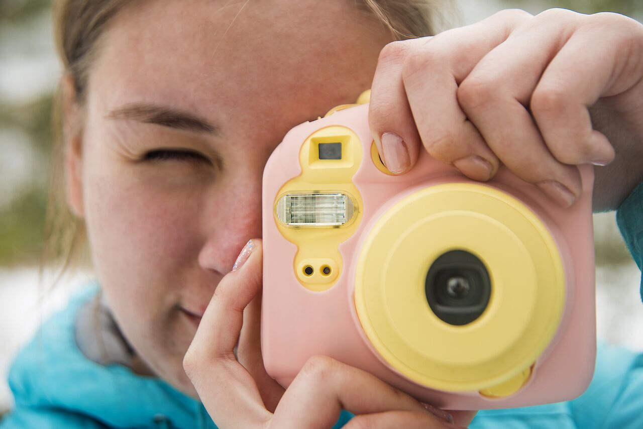 Young child taking a photo with an instant camera