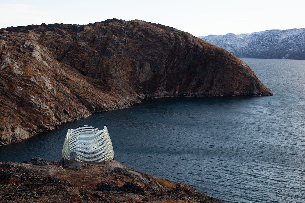 Glass igloo on the edge of a cliff in Greenland