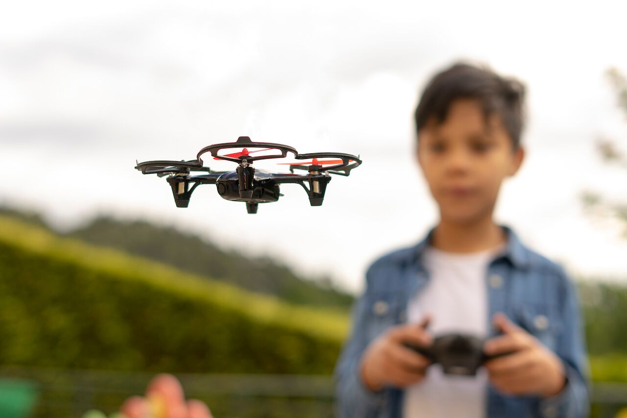 Close up of child flying drone in a park