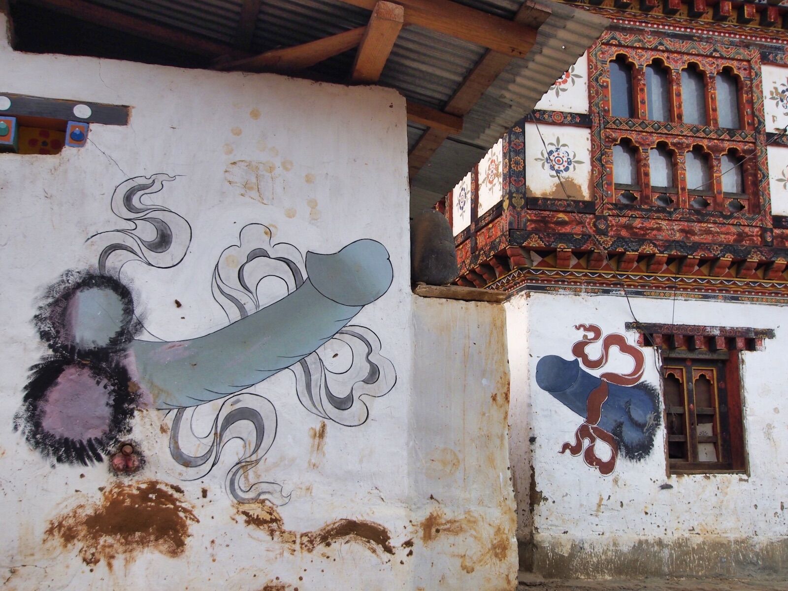Two penises painted on the walls of houses in Bhutan. Both paintings are elaborate and colorful.