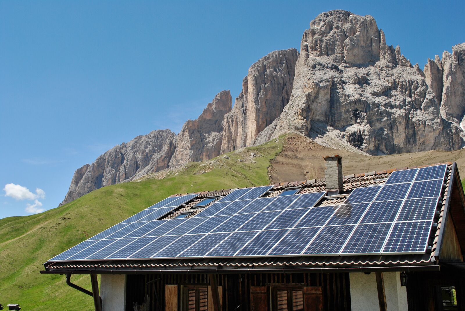 house roof with solar panels background of the Dolomites mountains