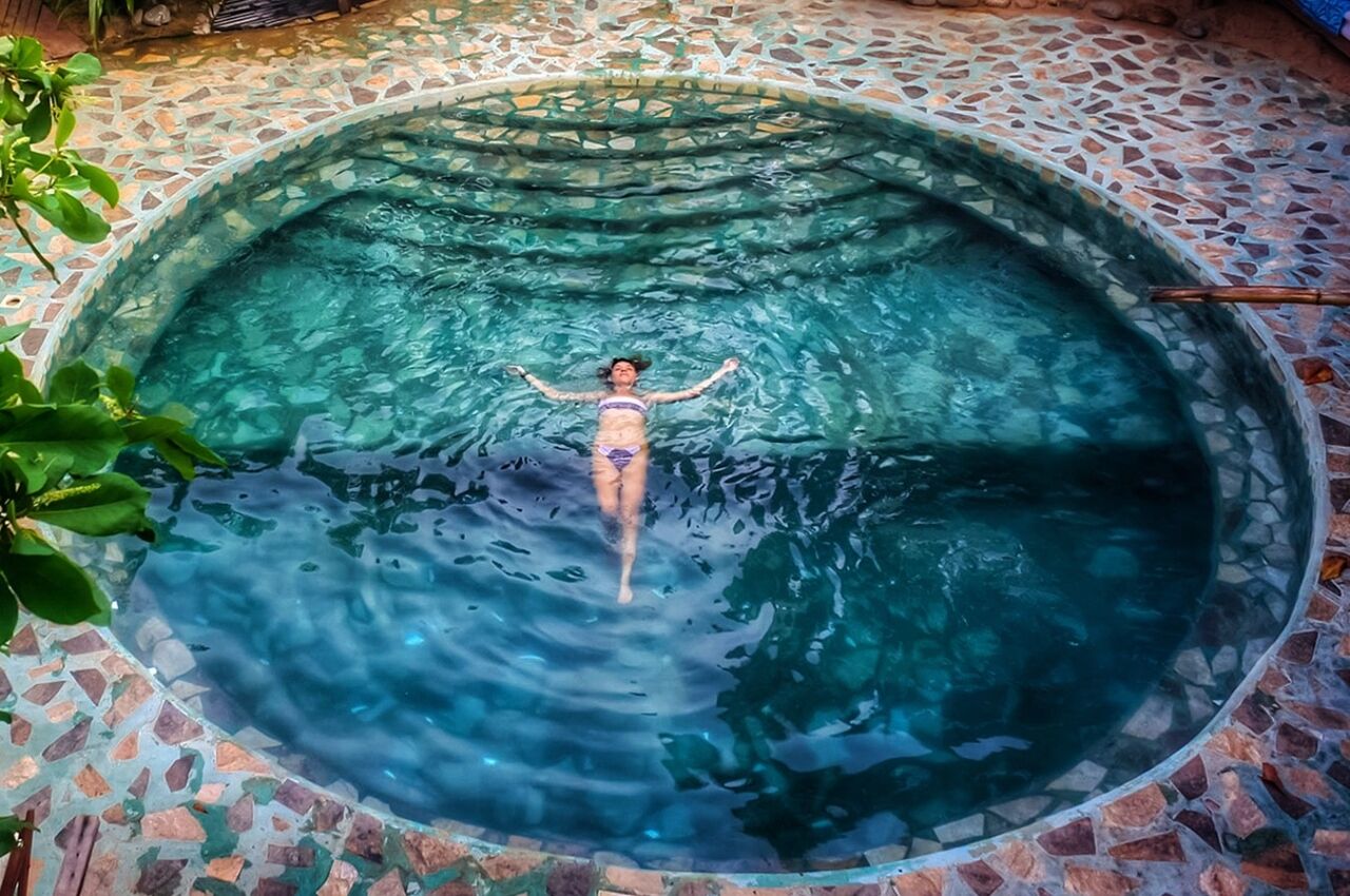 Girl floating in pool in Zipolite Mexico, one of the best gay travel destinations 