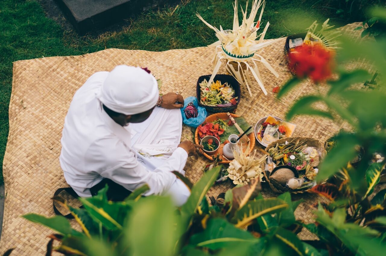 Person sits on woven mat surrounded by health food at detox health retreat 