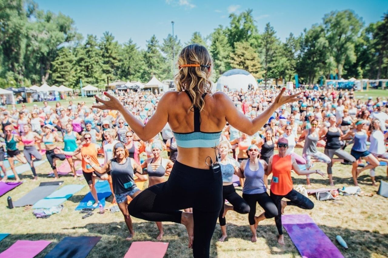 Woman stands in front of crowd at Wanderlust health retreat in US 