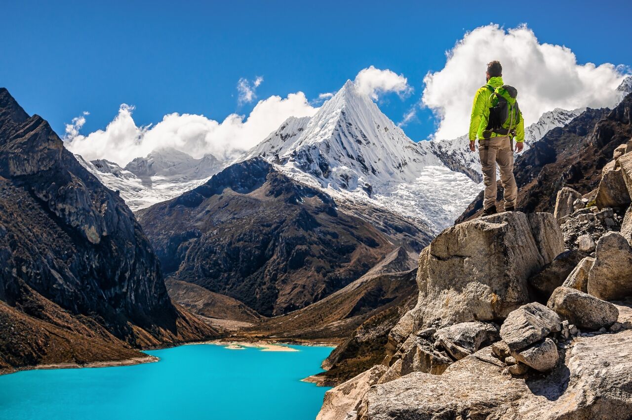 Man stands on edge of rock in Huascarán National Park a zodiac travel destination for Aquarius 