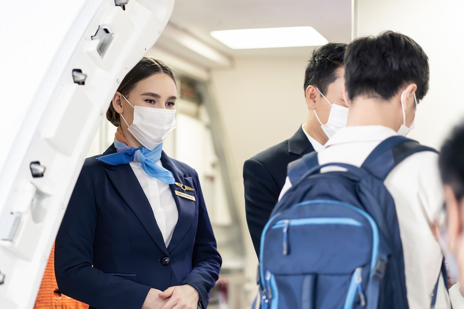 flight attendant helping passengers board
