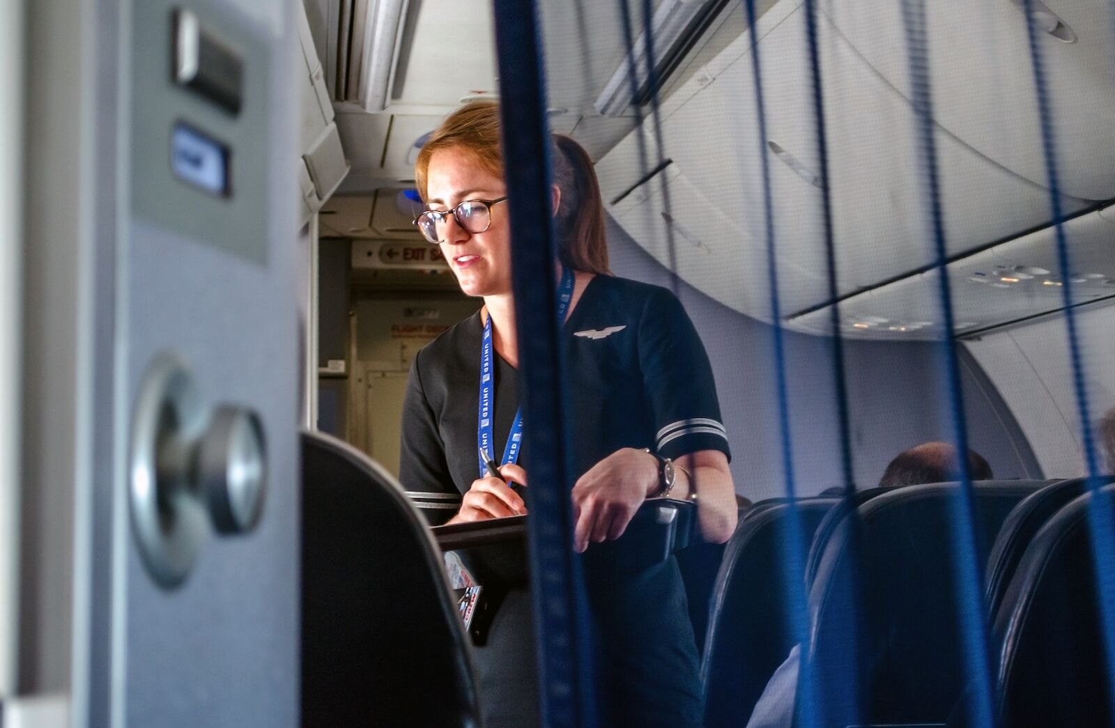 flight attendant helping passengers in business class