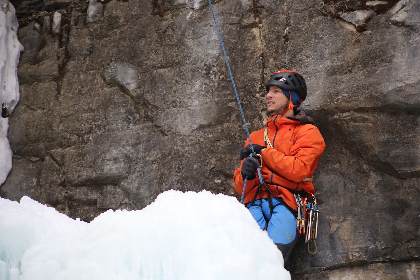 ice climber belaying against a wall