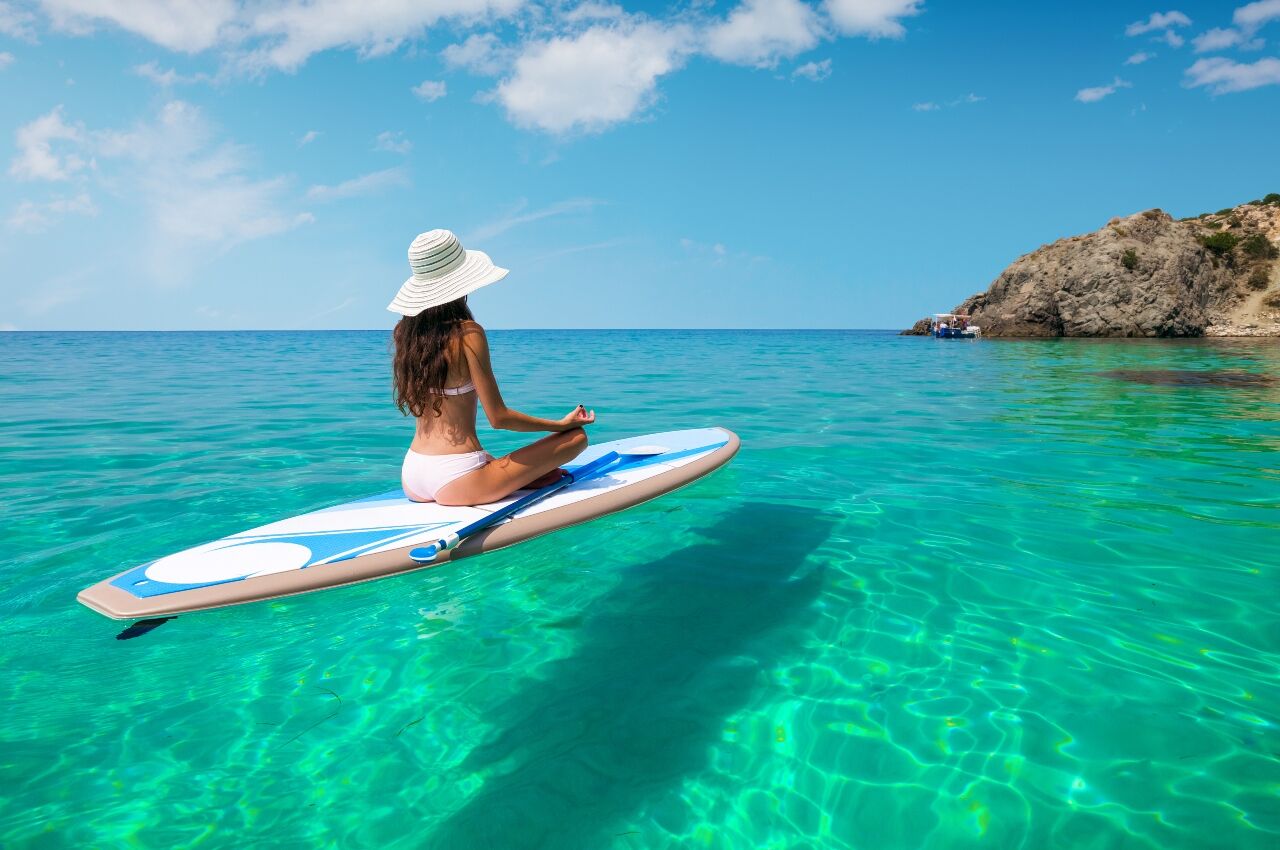 Woman sits on SUP board in Hawaii 